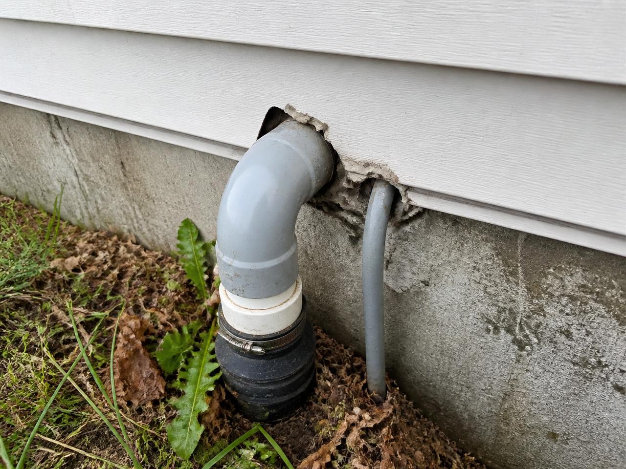 Gap in the foundation wall around a utility pipe penetration on the exterior of a home